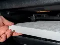 Hand byter ett nytt kupéfilter. Frågan är hur ofta byta kupefilter för ren luft i bilen.