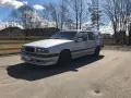 Silver Volvo 940 kombi, en klassiker med en pålitlig tomgångsmotor, parkerad utomhus en solig dag.
