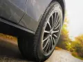 Michelin Primacy 4-däcket på en bil som kör på en väg i soligt höstväder.