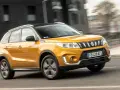 Gul Suzuki Grand Vitara körs på en stadsgata. Kanske ett problem med bilen som gör att den körs i hög fart?