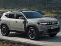En ny Dacia Duster på en grusväg med berg och sjö i bakgrunden. Perfekt för ett dacia duster test i naturen.