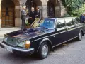Mörkblå Volvo 264 Bertone limousine parkerad framför en byggnad med män i kostym.