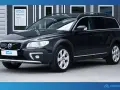 Svart Volvo XC70 parkerad framför en byggnad med skylten "Nordbil Välkommen". Bilen har takräcken och en robust design.