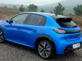 Blå Peugeot e-208 GT på grusväg. En elbil redo för peugeot e-208 test i naturen.