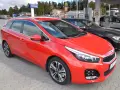 Röd Kia Ceed kombi parkerad vid en bensinstation. En perfekt bil för en kia ceed test.