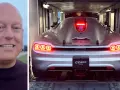 En man ler bredvid en silverfärgad Koenigsegg CC850 som lastas in i en trailer.