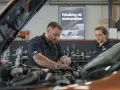 Två mekaniker felsöker ett motorproblem på en Fiat Ducato i verkstaden.