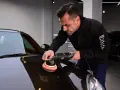Man använder polermaskin för att polera bilen till perfektion.
