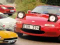 En samling klassiska sportbilar: en röd Mazda Miata, en gul Datsun, en vit Volvo P1800 och en röd Mercedes-Benz.
