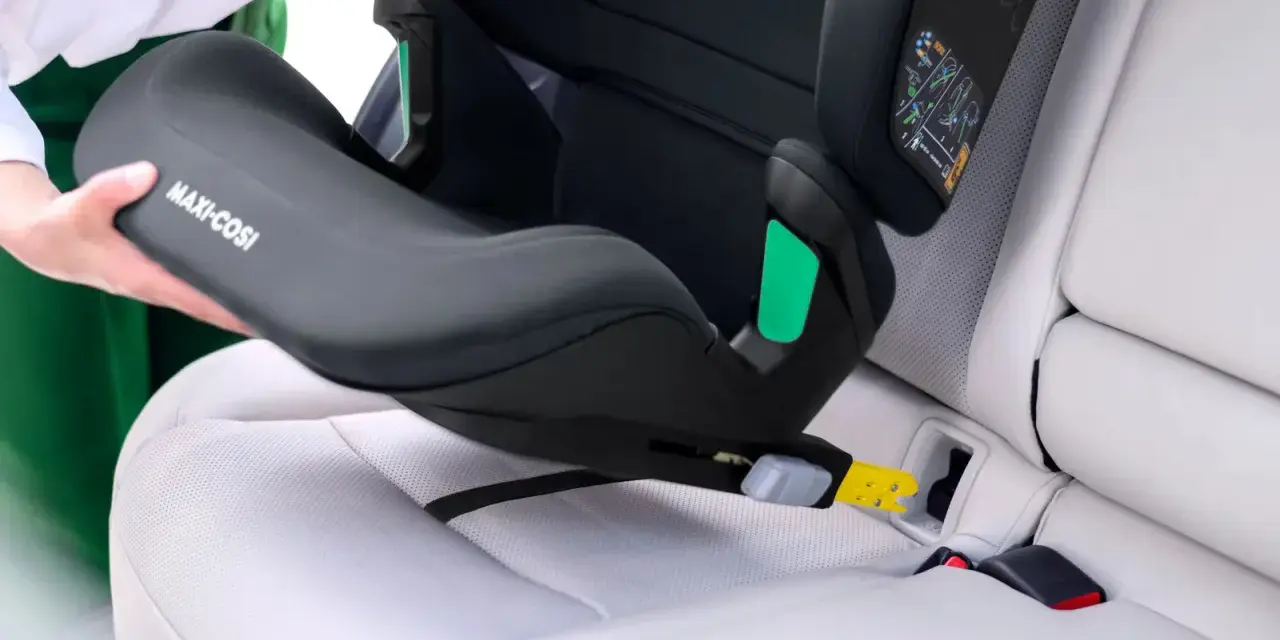 En person monterar en Maxi-Cosi bilbarnstol utan isofix i en bil. Barnstolen placeras på bilsätet och fästs med bilens säkerhetsbälte.