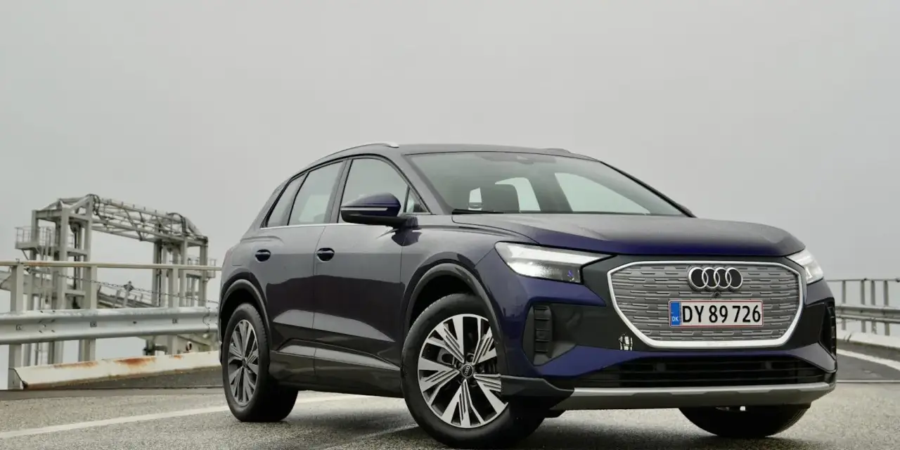 Mörkblå Audi Q4 e-tron på en väg med en bro i bakgrunden. En del av en audi q4 e-tron test.