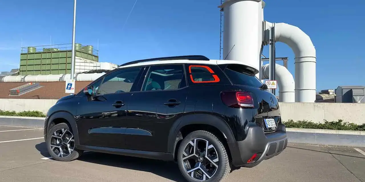 Svart Citroën C3, parkerad vid industribyggnad. Kanske ett problem med bilen?