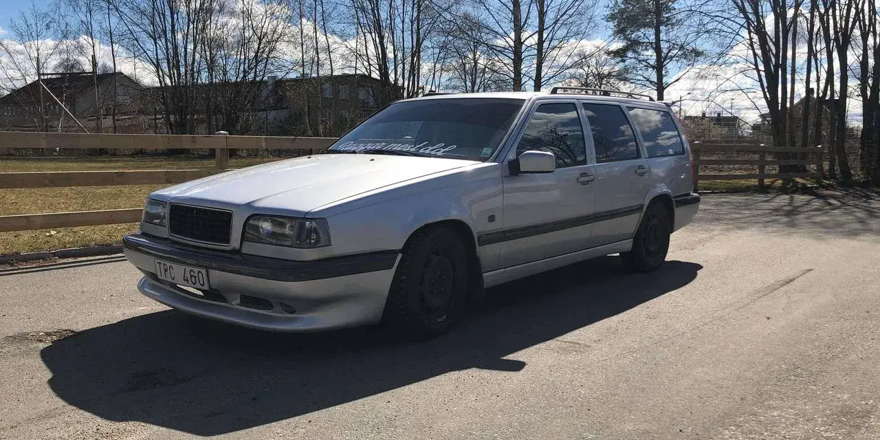 Silver Volvo 940 kombi, en klassiker med en pålitlig tomgångsmotor, parkerad utomhus en solig dag.