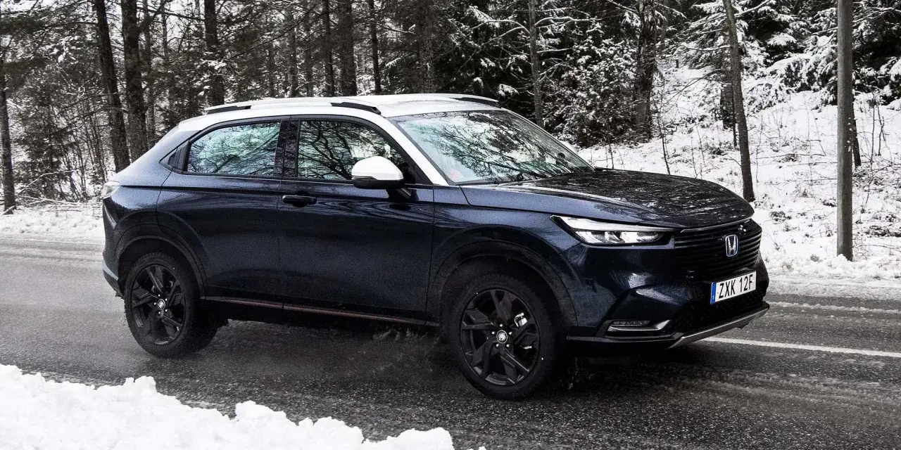 Mörkblå Honda HR-V i ett snöigt skogsparti, redo för ett vintertest.