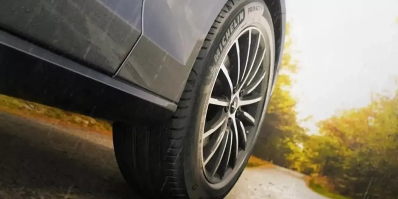 Michelin Primacy 4-däcket på en bil som kör på en väg i soligt höstväder.