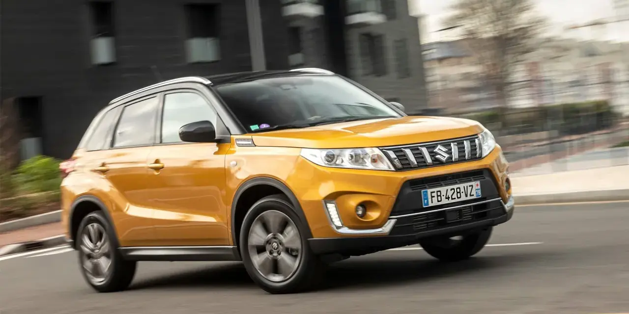 Gul Suzuki Grand Vitara körs på en stadsgata. Kanske ett problem med bilen som gör att den körs i hög fart?
