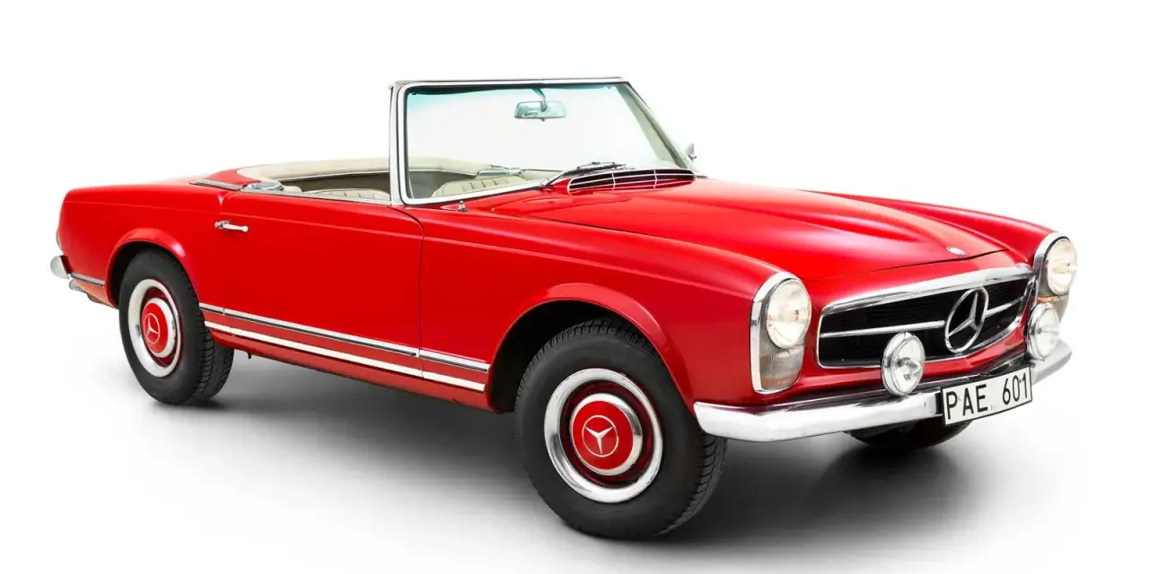 Röd cabriolet, en klassisk Mercedes 230 SL, med kromdetaljer och vit interiör.