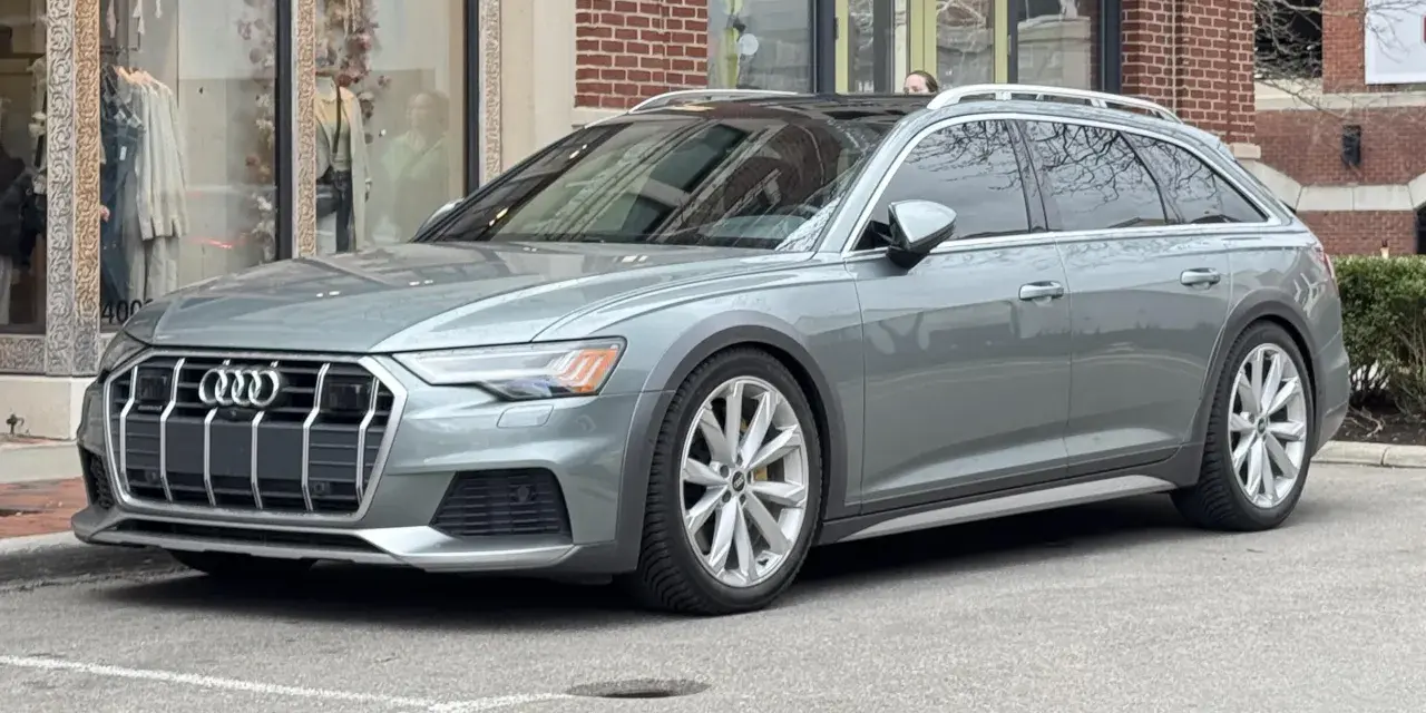 Grå Audi A6 Allroad parkerad utanför en butik. Kanske ett audi a6 allroad problem med parkeringen?