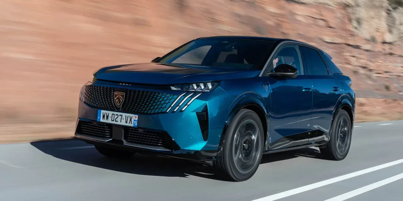 Blå Peugeot 3008 på en väg, redo för ett test. Bilen har en modern design med en distinkt grill och skarpa linjer.