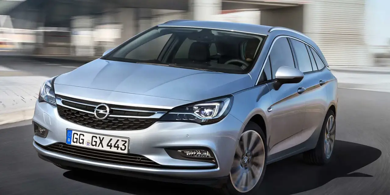 Silver Opel Astra kombi körs på en väg. En bra bil för familjen, perfekt för ett opel astra begagnad test.