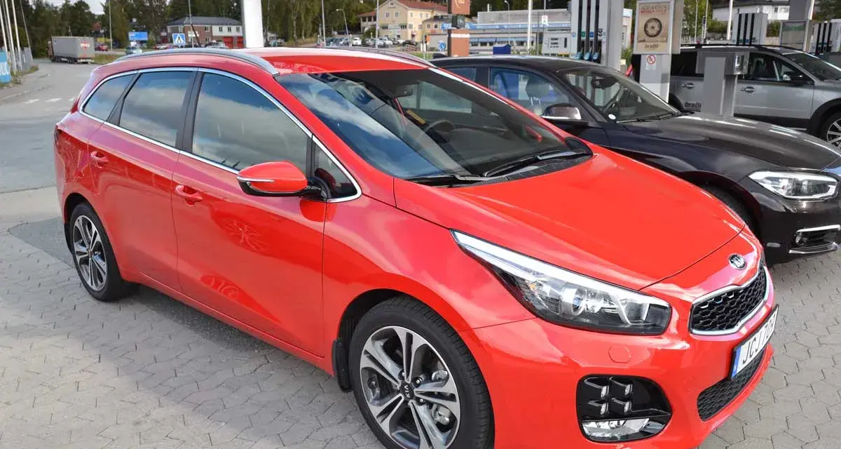 Röd Kia Ceed kombi parkerad vid en bensinstation. En perfekt bil för en kia ceed test.