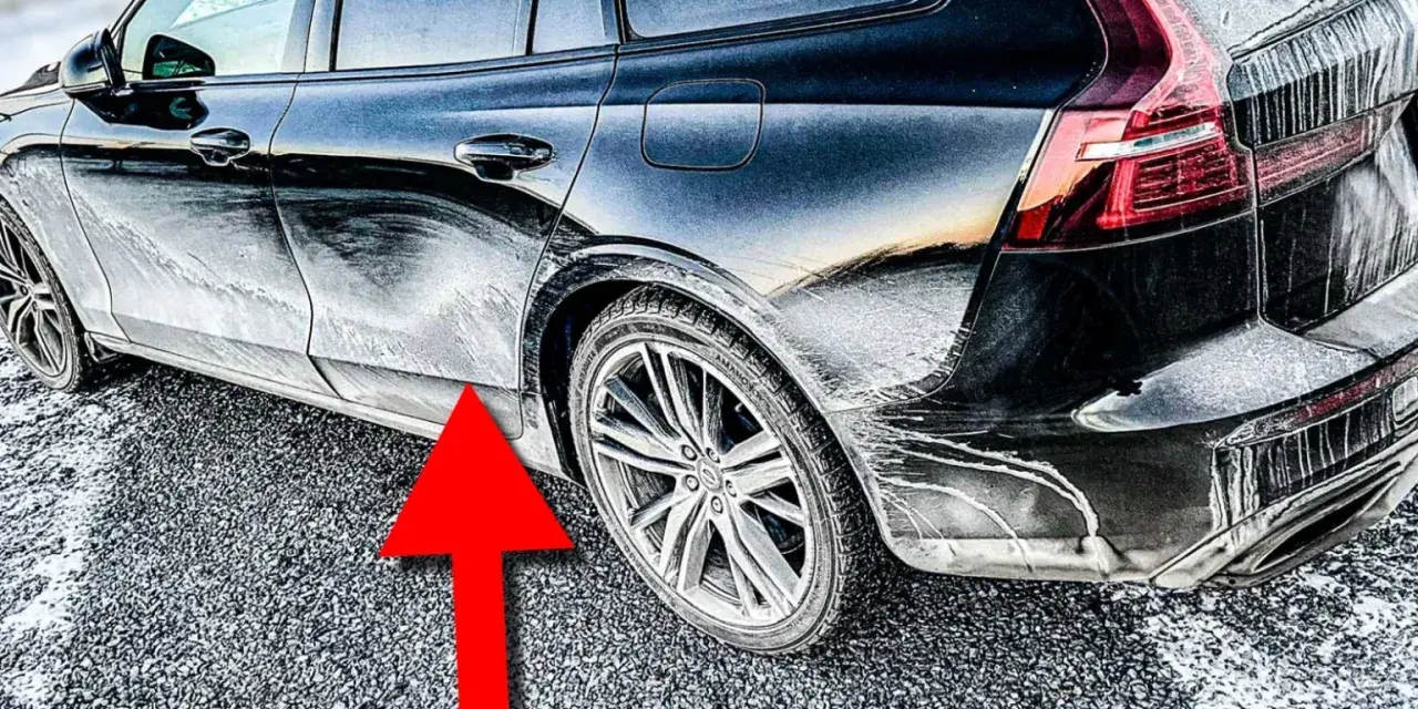 En mörk bil täckt av frost och smuts. En röd pil pekar mot en rostig bil.