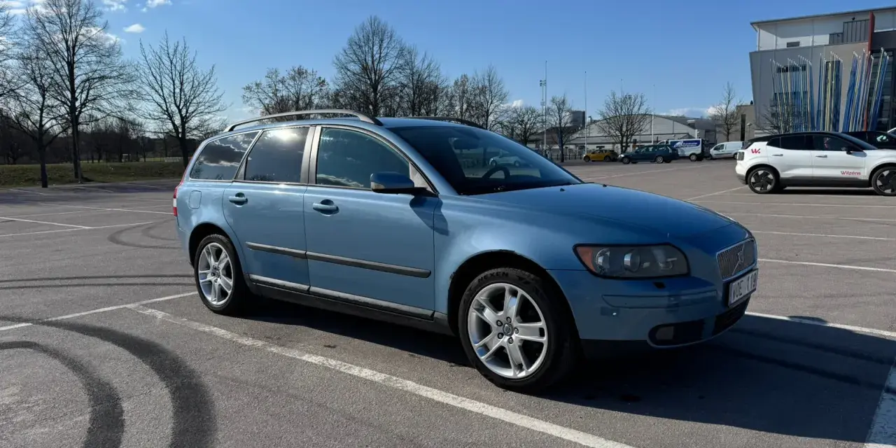 Blå Volvo V50 parkerad på en parkering. Dags att byta hjullager på V50:n.