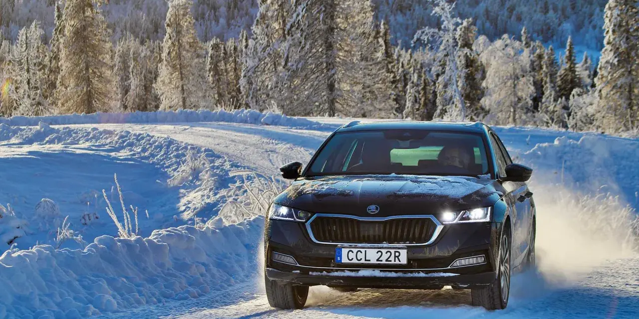 Skoda Octavia IV problem: bilen kör på en snöig väg i Sverige, omgiven av frostiga träd.