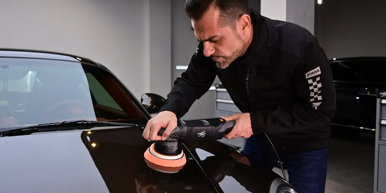 Man använder polermaskin för att polera bilen till perfektion.