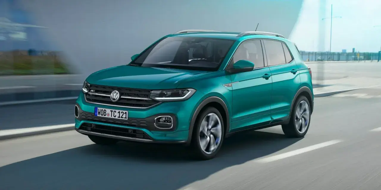 En turkos VW T-Cross kör på en väg. Inga problem med denna bil!