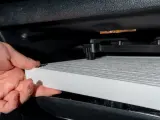 Hand byter ett nytt kupéfilter. Frågan är hur ofta byta kupefilter för ren luft i bilen.