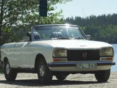 Vit cabriolet Peugeot 304 står vid en sjö.