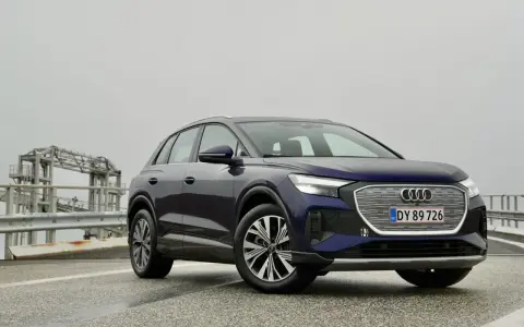 Mörkblå Audi Q4 e-tron på en väg med en bro i bakgrunden. En del av en audi q4 e-tron test.