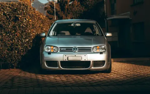 Silver VW Golf R32 framifrån. Bilen står parkerad på en stenlagd uppfart. Kanske dags att kolla styrled glapp?