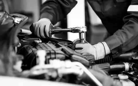 Mekaniker utför kamremsbyte på en Golf. Regelbundet kamremsbyte är viktigt för att följa serviceintervall och undvika dyra motorproblem.