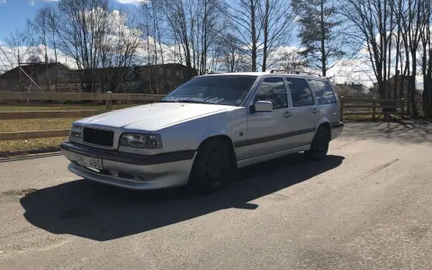 Silver Volvo 940 kombi, en klassiker med en pålitlig tomgångsmotor, parkerad utomhus en solig dag.