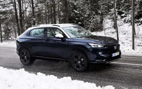 Mörkblå Honda HR-V i ett snöigt skogsparti, redo för ett vintertest.