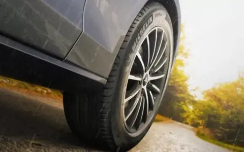 Michelin Primacy 4-däcket på en bil som kör på en väg i soligt höstväder.