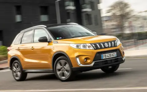 Gul Suzuki Grand Vitara körs på en stadsgata. Kanske ett problem med bilen som gör att den körs i hög fart?