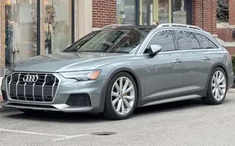 Grå Audi A6 Allroad parkerad utanför en butik. Kanske ett audi a6 allroad problem med parkeringen?