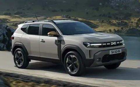 En ny Dacia Duster på en grusväg med berg och sjö i bakgrunden. Perfekt för ett dacia duster test i naturen.
