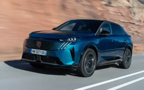 Blå Peugeot 3008 på en väg, redo för ett test. Bilen har en modern design med en distinkt grill och skarpa linjer.
