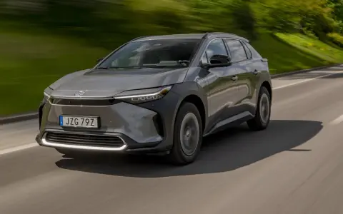 Grå Toyota bZ4X kör på en landsväg. Trots att det är en elbil, finns det ett känt toyota bz4x problem med hjulen.
