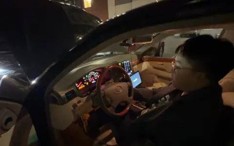 Personen försöker starta bilen, men den startar inte, bara klickar. Motorhuven är öppen och en laptop är på passagerarsätet.