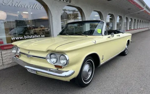 Gul cabriolet Chevrolet Corvair från 1960-talet parkerad utanför Bilstallet.