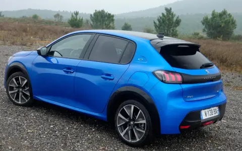 Blå Peugeot e-208 GT på grusväg. En elbil redo för peugeot e-208 test i naturen.
