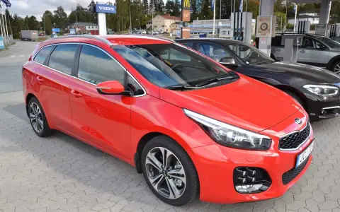 Röd Kia Ceed kombi parkerad vid en bensinstation. En perfekt bil för en kia ceed test.