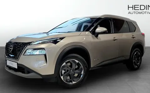 A tan Nissan X-Trail e-POWER SUV is shown from the front three-quarter view in a showroom.
