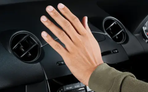 Handen känner efter luften från bilens ac.