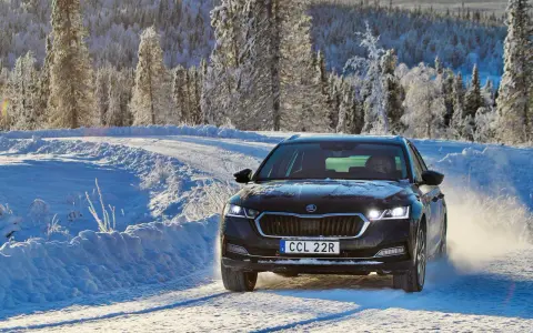 Skoda Octavia IV problem: bilen kör på en snöig väg i Sverige, omgiven av frostiga träd.